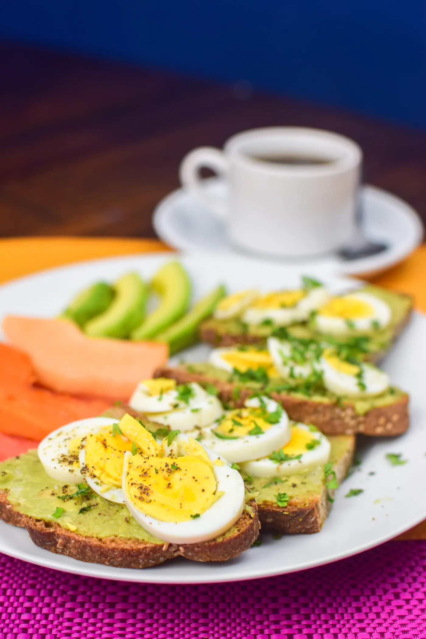 Tostadas con aguacate y huevo, papaya y café.